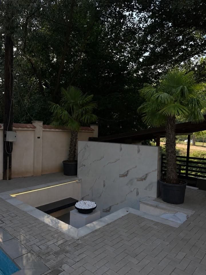 Terasă cu palmieri și zonă de relaxare la Villa Palm